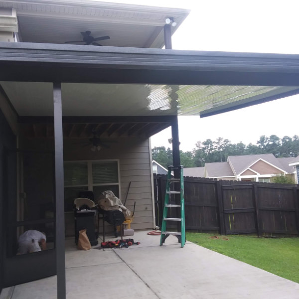 Aluminum patio cover creating shade over a backyard seating area